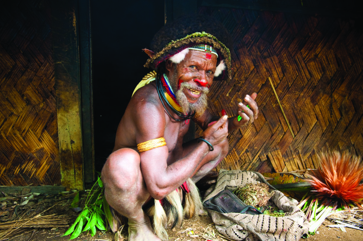 Hombre de las Highlands de Papúa Nueva Guinea pintándose la cara